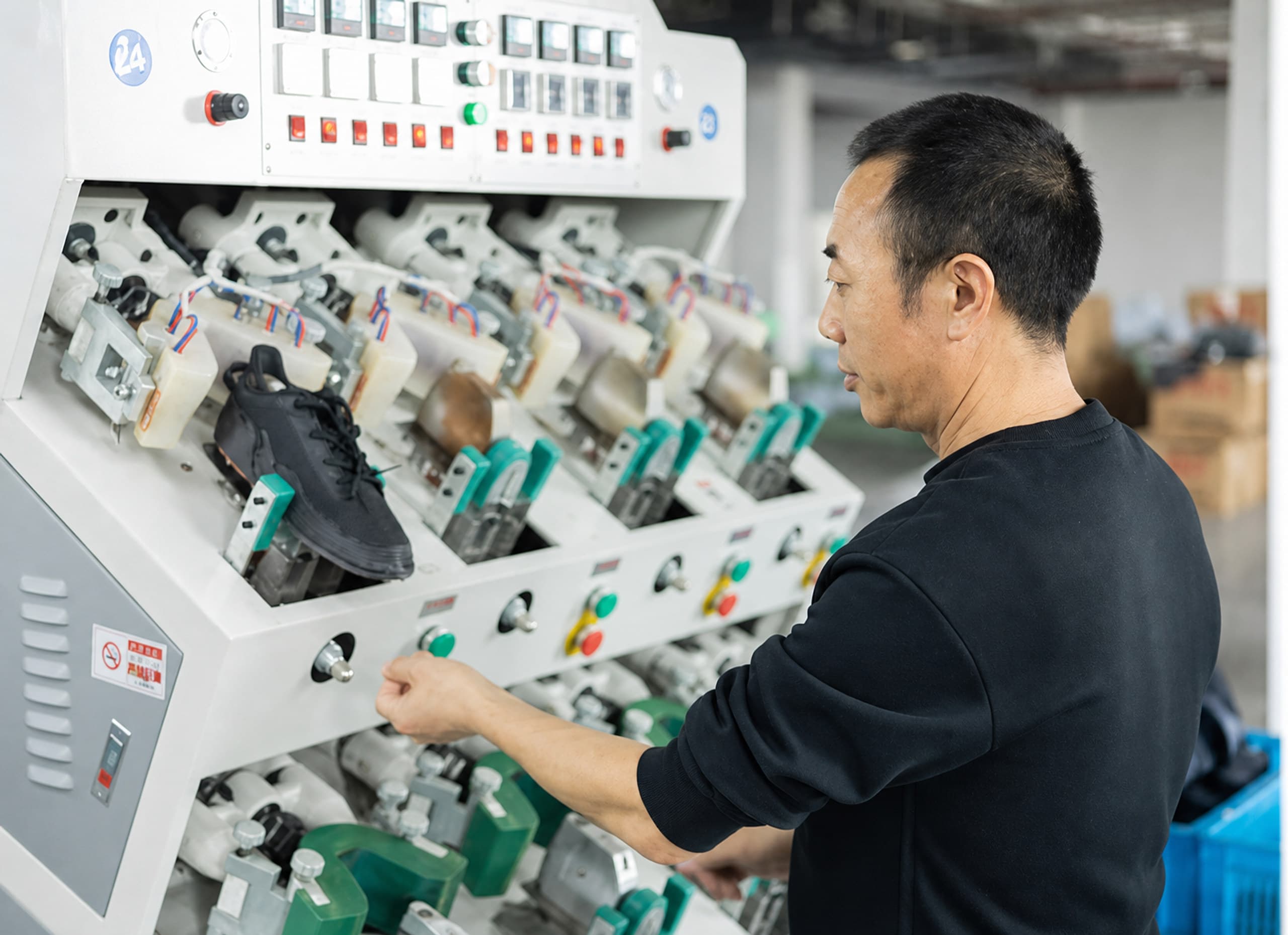 Footwear process operator checking production equipment controls